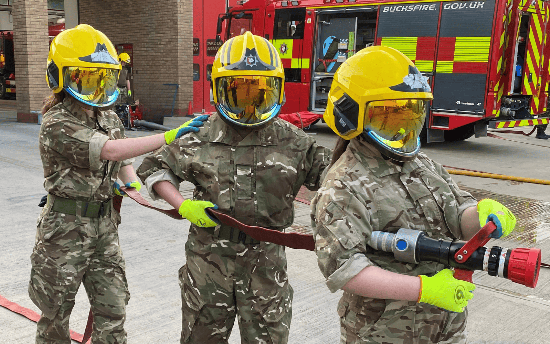 three young cadets holding a fire hose