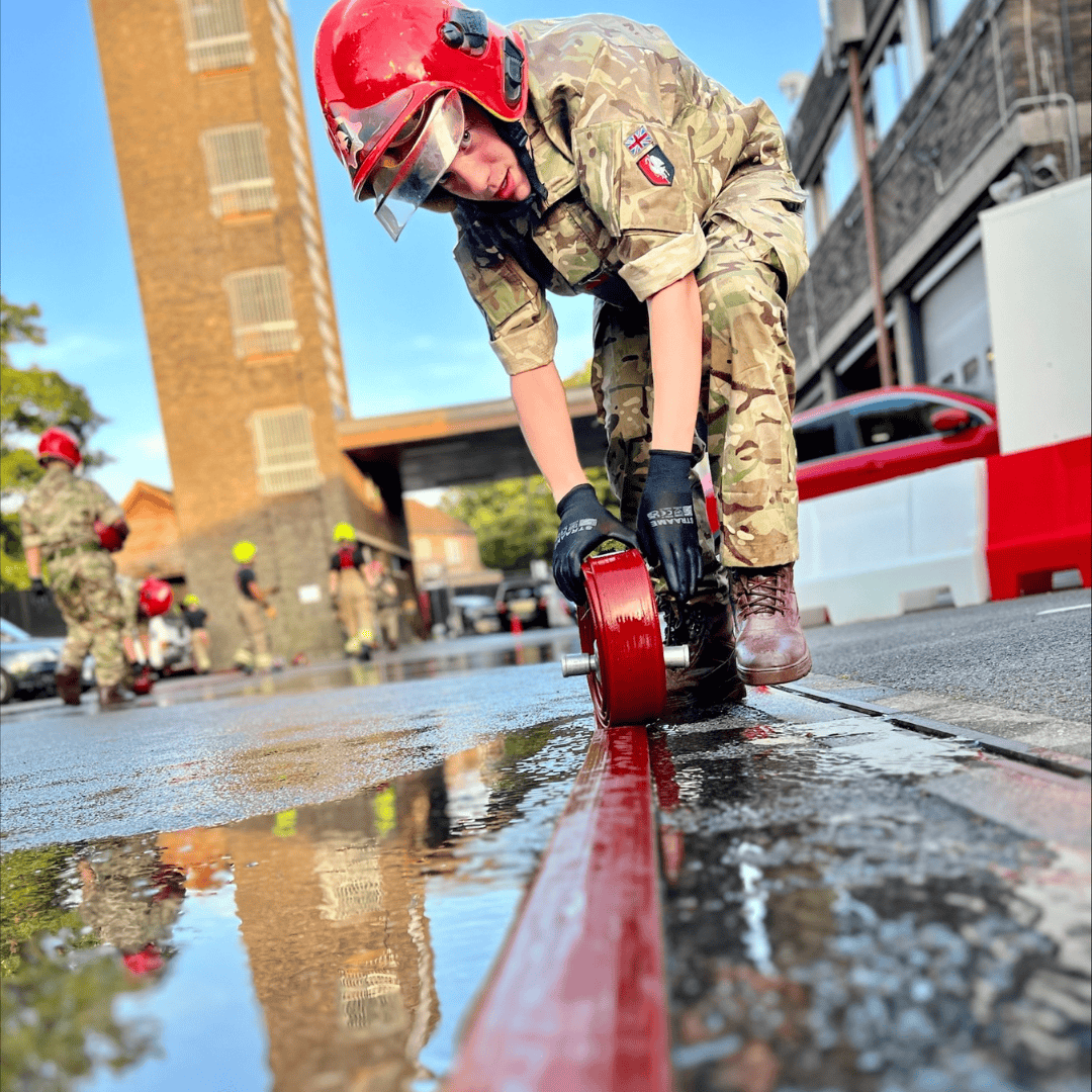 army cadet rolling up red hose