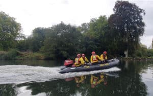 Beaconsfield water rescue boat and crew out on the river, with tree lined background.